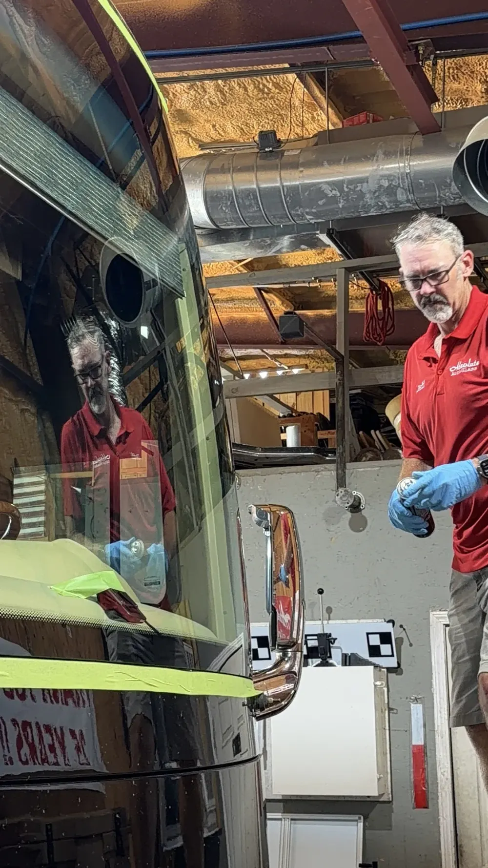 An Absolute Auto Glass technician beside a motorhome